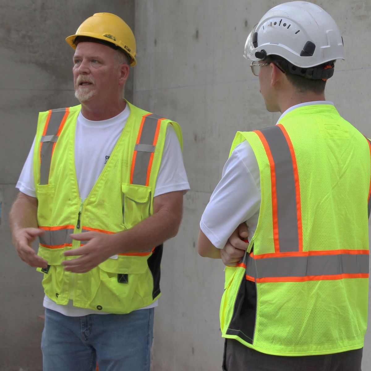 Photos of Surveyors. CNC Surveying business owner Tim Conway (in yellow hardhat) explains scanning process to contractors and another surveyor (white hardhat)