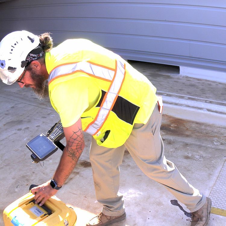 Surveyor setting up equipment for construction staking.